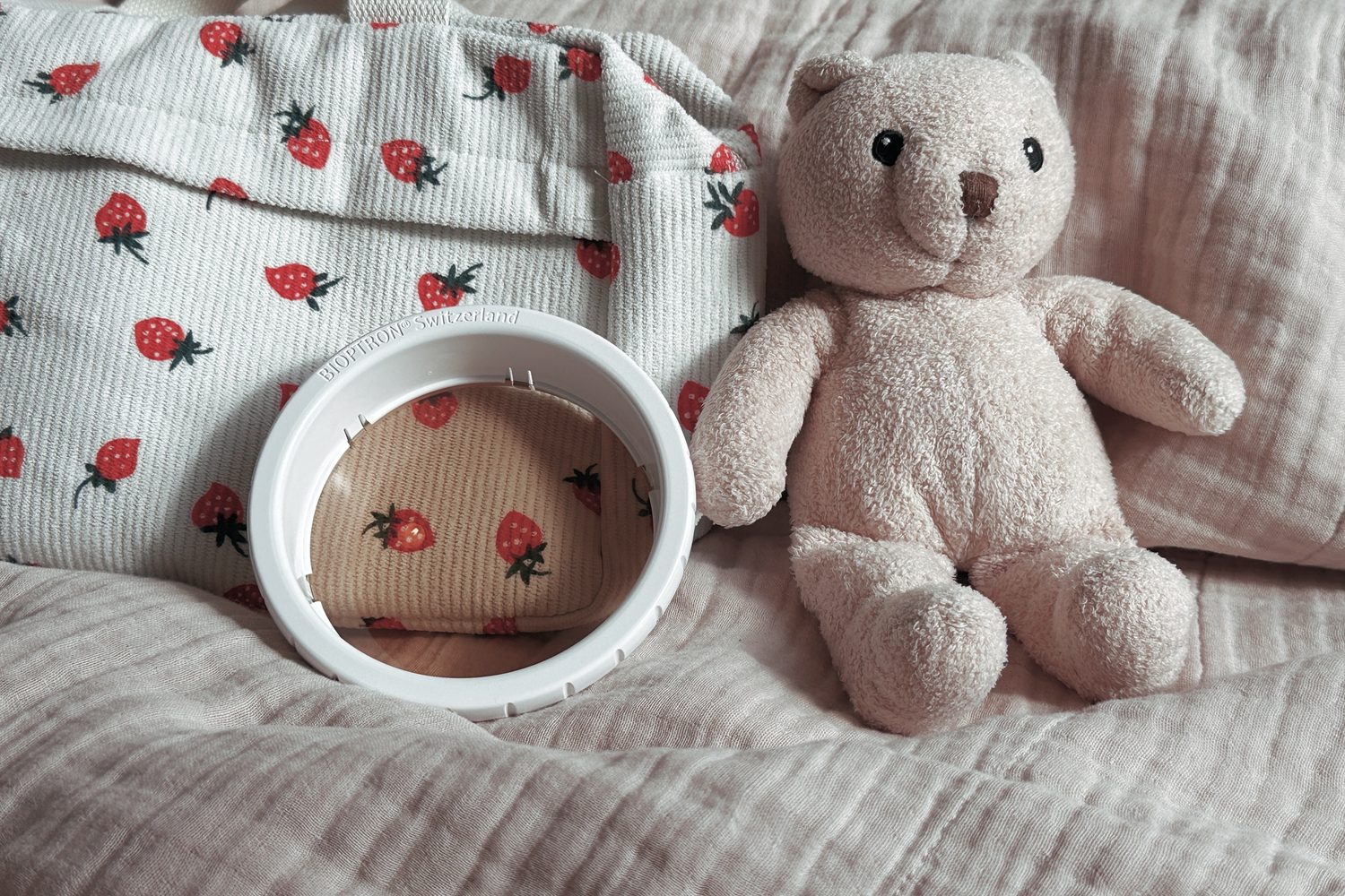 Bioptron-Aufsatz neben Erdbeer-Wickeltasche und Teddybär – Lichttherapie als sanfter Begleiter im Familienalltag