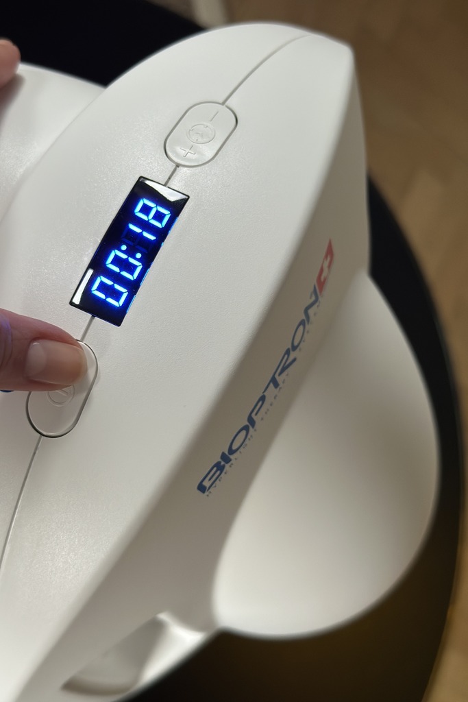 Bioptron PRO 1 Lampe mit leuchtendem blauem Display und Bedienknopf — Schweizer Lichttherapie-Gerät im Einsatz
