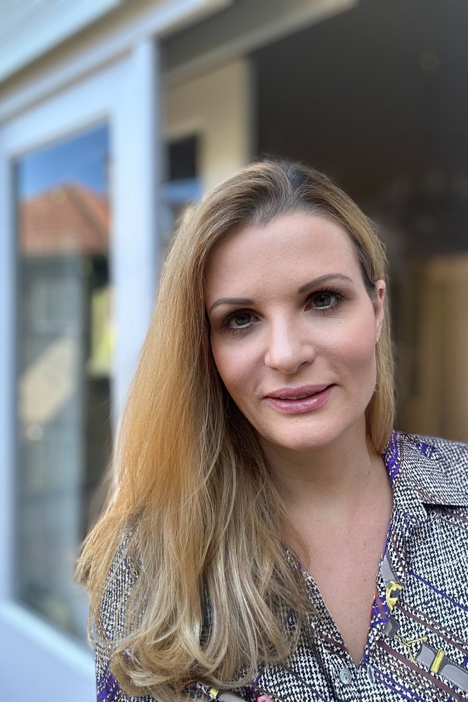 Andrea Viehauser, Gründerin von andrea-viehauser.at, im Porträt vor einem Wiener Altbau — persönlicher Hintergrund hinter den Empfehlungen auf dieser Website.