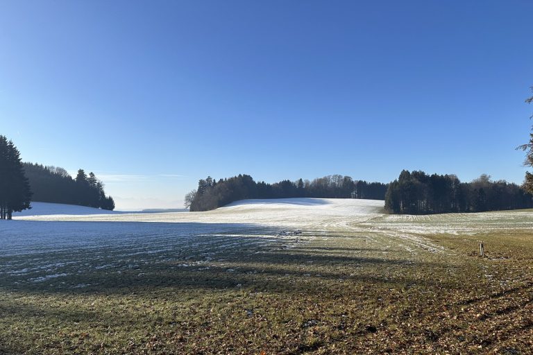 Verschneite Winterlandschaft mit klarem blauen Himmel und Bergsilhouetten am Horizont – Sinnbild für die Klarheit nach dem morgendlichen Gedämpftsein