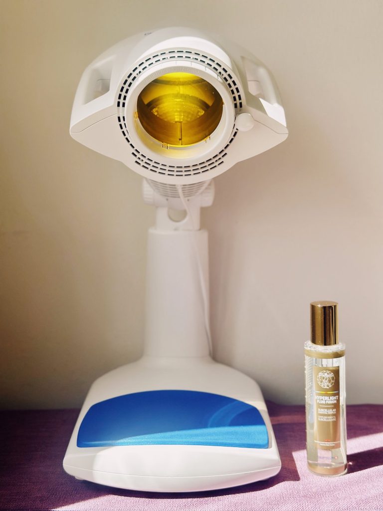 Bioptron PRO 1 mit gelbem Farbaufsatz im Einsatz, daneben das Hyperlight Fluid Fusion Spray von Zepter – das Morgenritual mit Lichttherapie