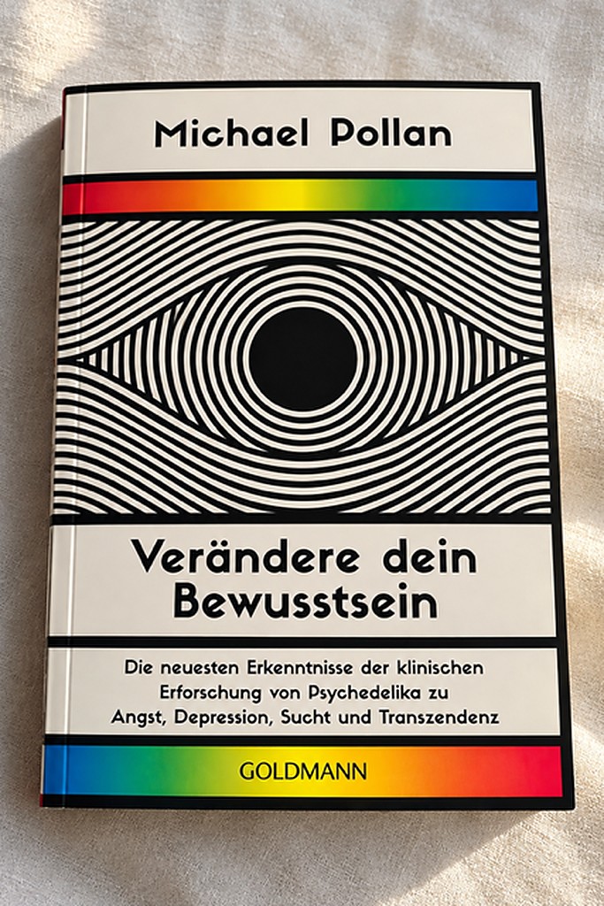 Das Taschenbuch „Verändere dein Bewusstsein" von Michael Pollan mit schwarz-weißem Op-Art-Auge und Regenbogenstreifen auf dem Cover, liegend auf hellem Leinen.